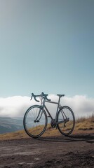 Obraz premium A single road bike standing upright on a hilltop against a bright overcast sky, creating a crisp and serene scene