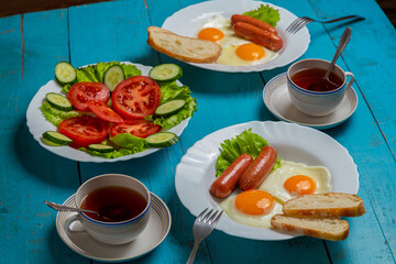 Breakfast for two persons fried eggs with sausages crispy white bread vegetable salad