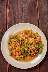 Couscous with vegetables in sauce on a plate on the table next to a fork. Copy space