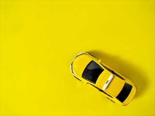 yellow toy taxi car on yellow paper background