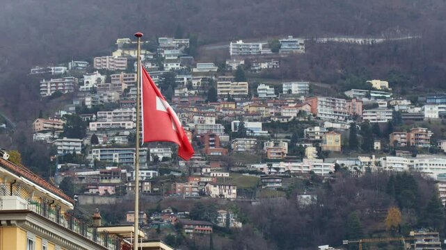 Swiss flag waving with Monte Bre in the background, Lugano, Switzerland