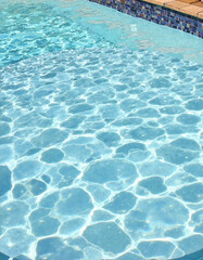 Crystal clear swimming pool water with mosaic tiles