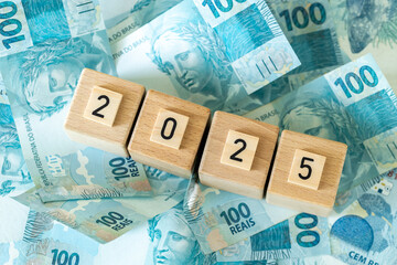 Brazil finances 2025. Brazilian money and wooden blocks with the date 2025. Economic analysis of...