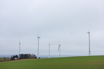 Large windmills in a field that produce energy. Windmill energy production.