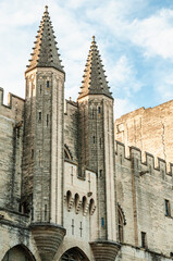 Front view, medium distance of, twin towers and entry to a 1700's castle wall, protecting Avignon village, from invasion, in mid-morning sunlight, France