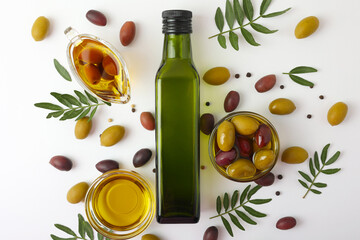 A beautifully arranged Olive Oil Bottle alongside Fresh Olives and vibrant Green Leaves 