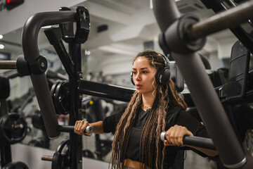 Fototapeta na wymiar young sporty woman do chest exercise on chest press machine at gym