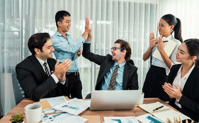 Group of happy businesspeople in high five gesture and successful efficient teamwork. Diverse race office worker celebrate after made progress on marketing planning in corporate office. Habiliment