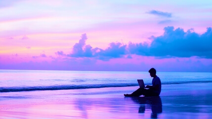 Man works on laptop by the calm ocean waves during twilight with soft blue and purple hues