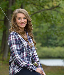 Beautiful young woman in flannel shirt with fishing pole - country girl gone fishing'