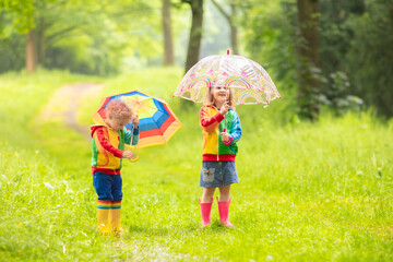 Kids playing in the rain with umbrella