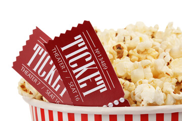Tasty popcorn and movie tickets isolated on white