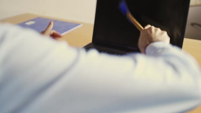 Tech fail. Tecnhnical problems. Male Hand smashing laptop with hammer