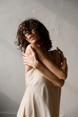 Young pretty dancer puts her arms around her shoulders while doing dance moves