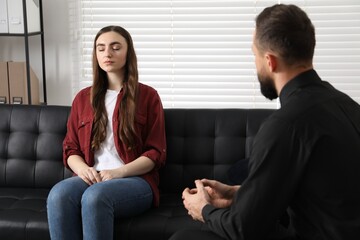 Psychologist working with patient during hypnosis session indoors
