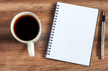 Blank notepad with cup of coffee and pen flat lay