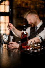 Selective focus on black label whiskey bottle with metal cocktail jigger