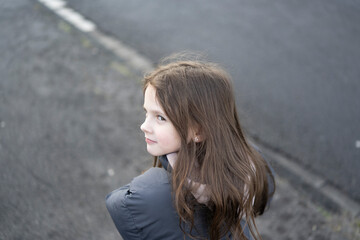 Little cute warmly dressed girl without hat outdoors. Concept of active healthy child outdoors