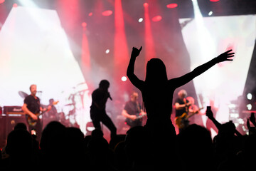 Silhouetted figure dancing at a rock concert