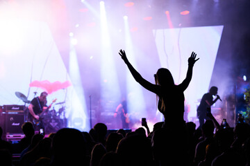 Excited fan with arms raised at gripping live concert