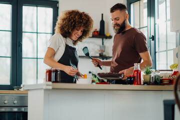 Happy couple cooking together in modern kitchen