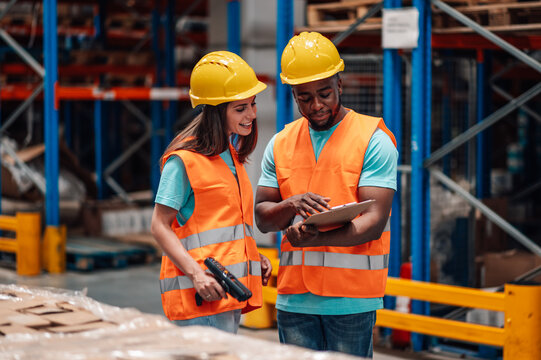 Warehouse workers checking inventory using barcode scanner and clipboard