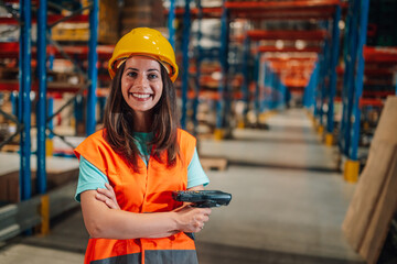 Smiling warehouse worker holding barcode scanner in distribution center