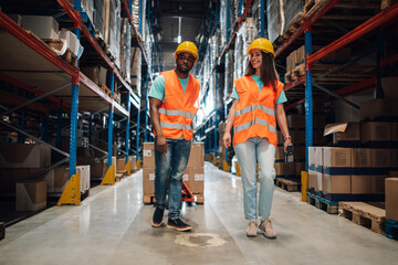 Warehouse workers walking and transporting goods in logistics center