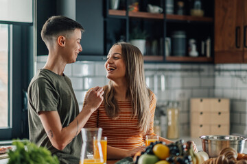 Lesbian couple sharing a moment of joy while preparing breakfast in the kitchen
