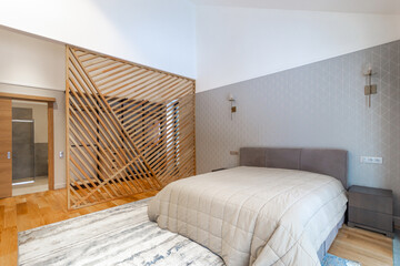 Bedroom in a modern country house. The room is complemented with decorative elements made of wood.