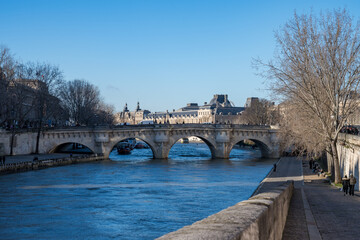 Fototapeta premium Breathtaking view of a historic bridge over a serene river in Paris