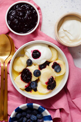 Lazy cottage cheese dumplings with blueberry sauce, sour cream and butter.top veiw
