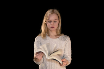 Blonde girl reading a book in cozy sweater on black background