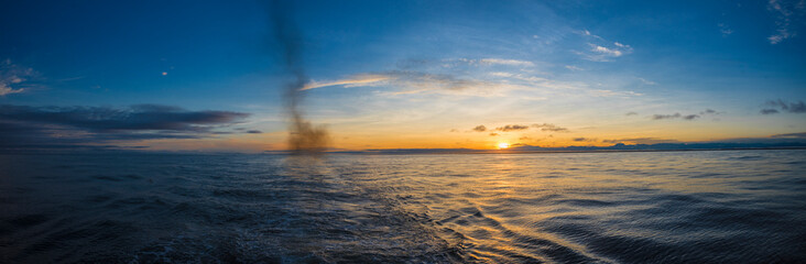 Fototapeta premium Beautiful and peaceful sunrise seen from a boat in the middle of the ocean 