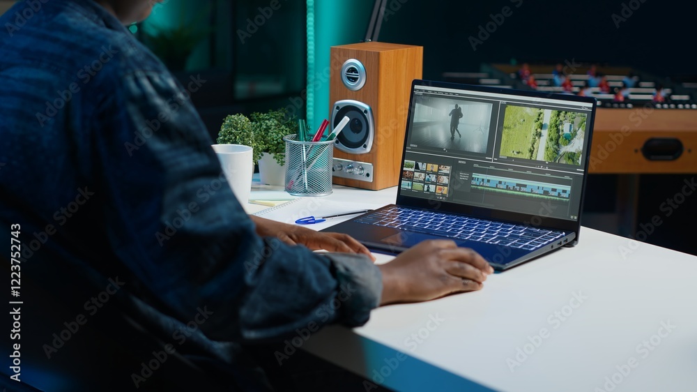 Poster video editor selecting key frames to use while doing video montage, working from home on notebook de
