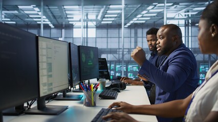 Surprised data center technician celebrating after successfully managing to install cybersecurity framework, reducing security incidents and enhancing data protection protocols, camera A