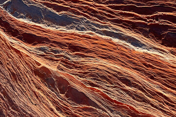 Natural patterns of red and orange minerals in rock formations in the desert landscape