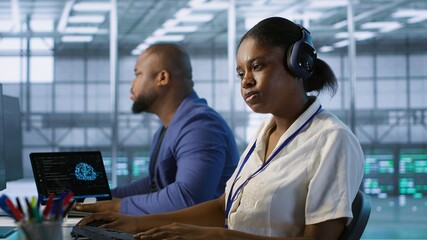 Data center engineer wearing headphones enjoying songs, maintaining company network infrastructure....