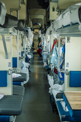 Fototapeta premium Passengers are relaxing on a third class carriage of a russian train, enjoying the journey and the passing landscapes