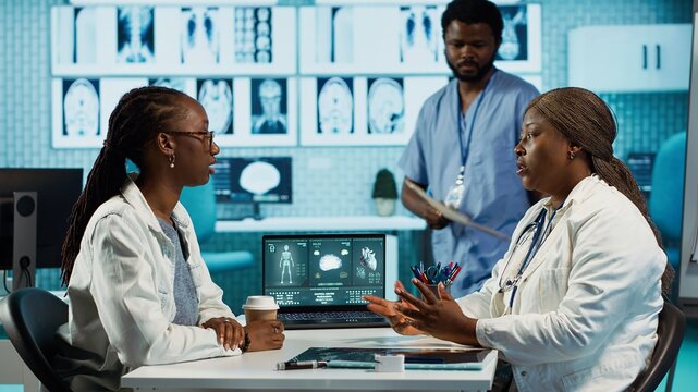Black medical staff and patient discussing diagnostic feedback and records, emphasizing expertise and data driven decision making. Young adult listens to professional advice for wellness. Camera A.