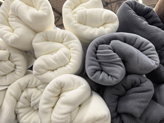 Cozy rolled blankets in soft shades ready for a warm evening