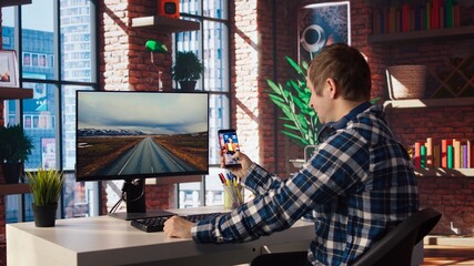 Man at home watching social media live broadcasts, interacting in chat with online content creators. Person holding phone, using social network app to partake in livestreams, camera A