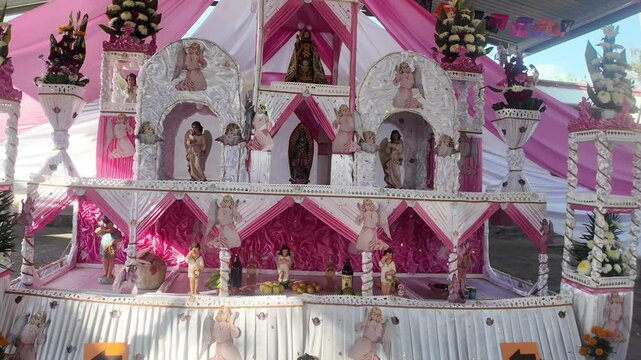 A pink and white display of flowers and statues