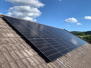 Dark Tiled Roof of a Residential House with Installed Solar Panels