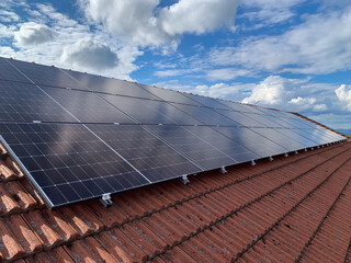 Red Tiled Roof of a Residential House with Installed Solar Panels