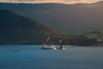 Early Phase of Peljesac Bridge Construction in Croatia Featuring Massive Floating Cranes, Cargo Ships, and Advanced Engineering on the Adriatic Sea