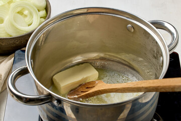 butter is being melted in a pot. Process of making french onion soup, food closeup, melting butter...