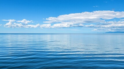 Obraz premium Tranquil Seascape with Gentle Waves Under a Bright Blue Sky and Fluffy White Clouds