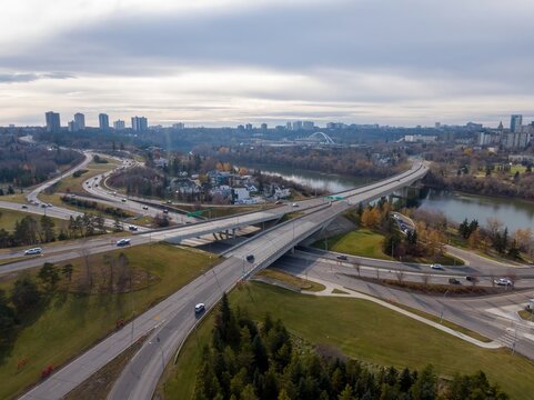High-angle view of Edmonton city highway intersection over a river, with cars traversing the overpass. Urban landscape surrounds the roadway. Cloverdale, Edmonton, Alberta, Canada