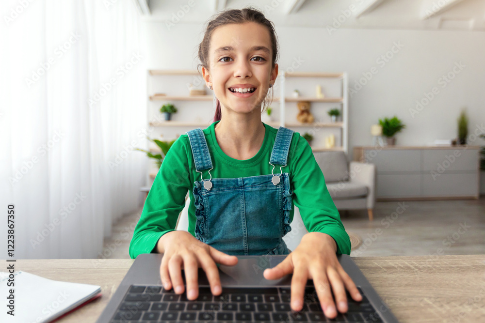 Poster doing homework. portrait of smiling student using laptop, studying online at home, happy girl typing